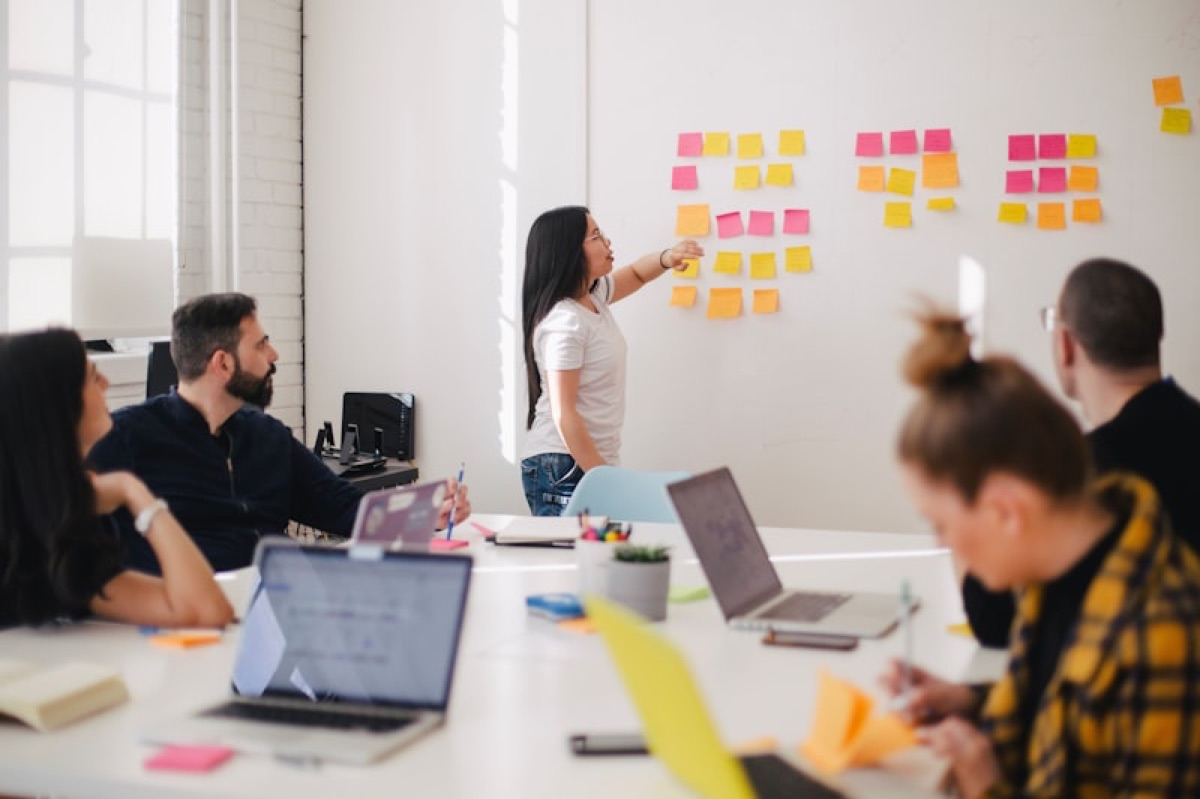 Small team planning together around a table with laptops and sticky notes